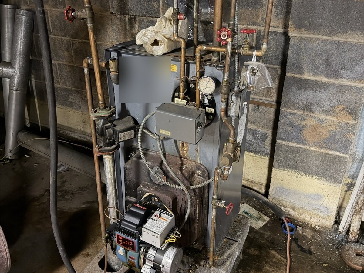 Before: an older gray oil boiler in a basement