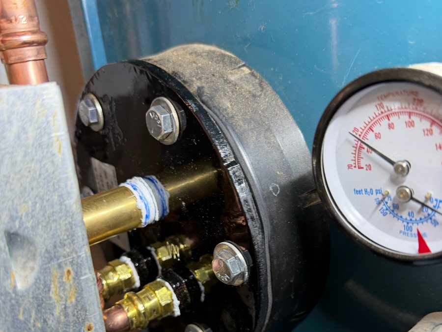 Boiler pressure gauge beside a circulator flange