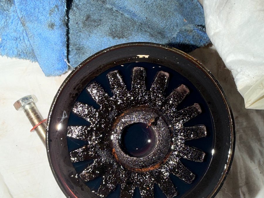 Opened oil filter housing with dark sludge on the strainer