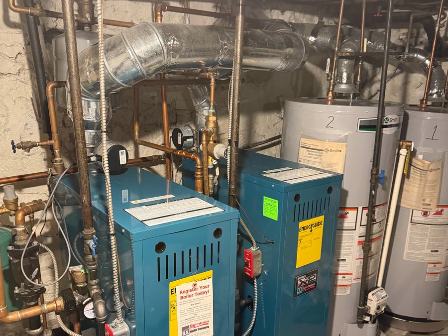 Two gas boilers with tank water heaters behind them