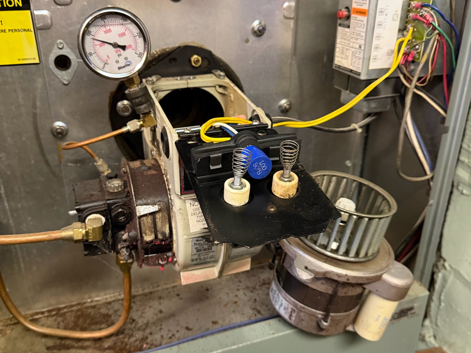 Oil burner pulled out of a boiler with the electrodes exposed for a tune-up