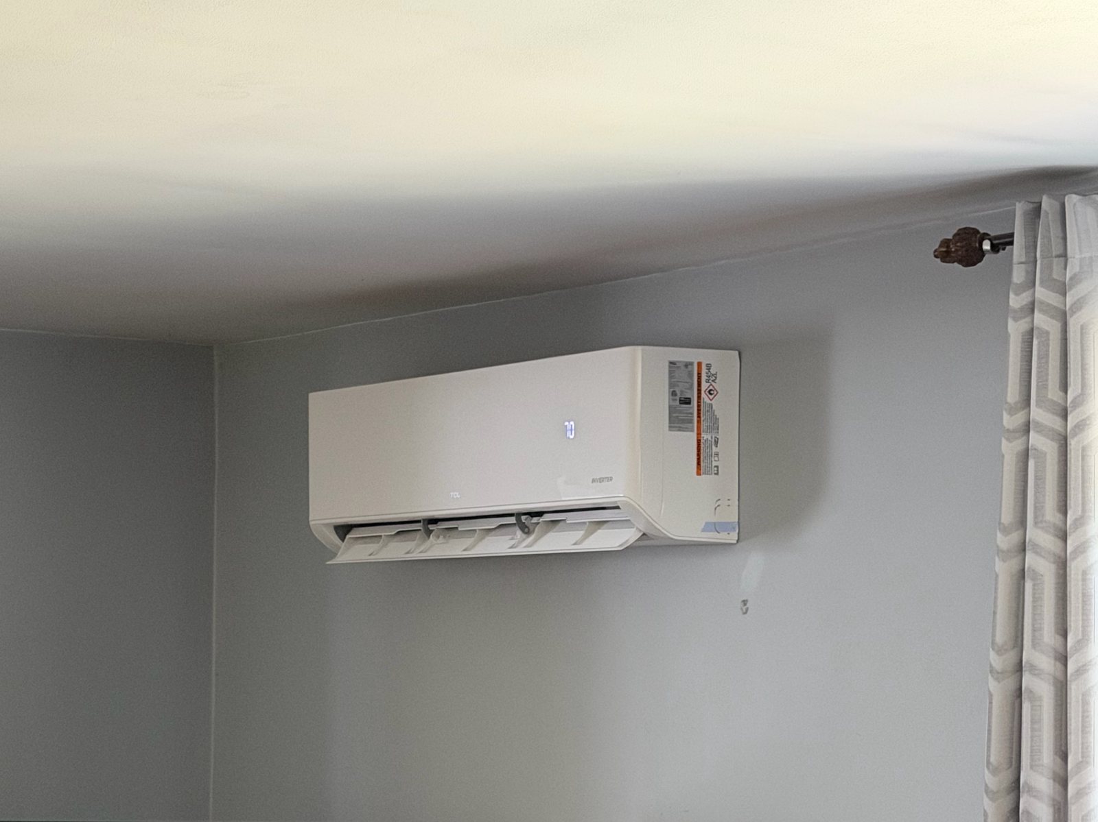 Ductless indoor unit mounted high on a living room wall