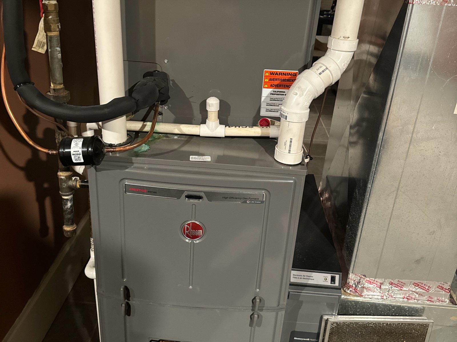 Rheem furnace with PVC venting installed in a utility room
