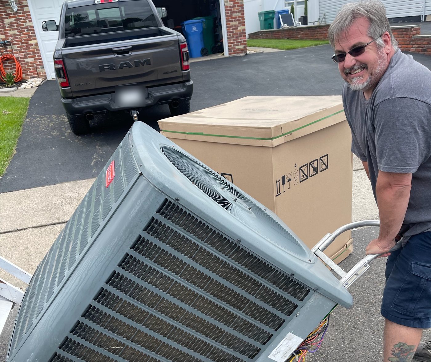 C&L technician moving a new air conditioner condenser on a hand truck