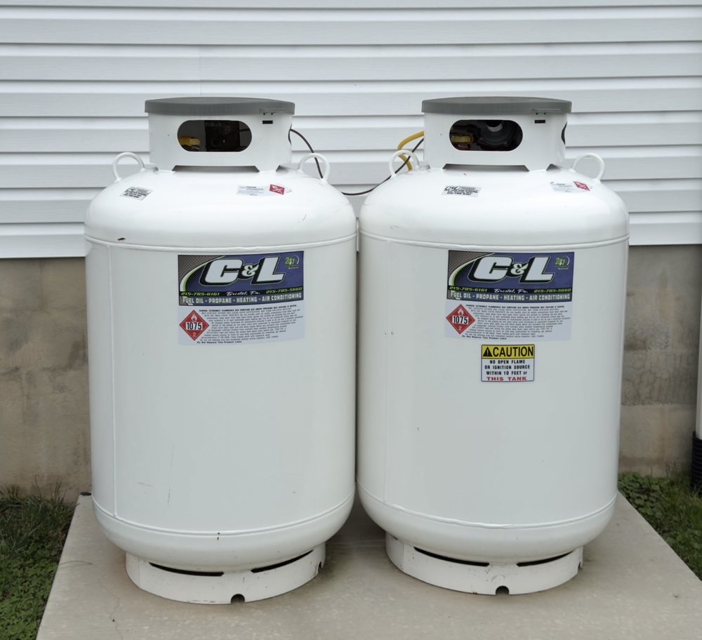 Two C&L-labeled residential propane tanks beside a house
