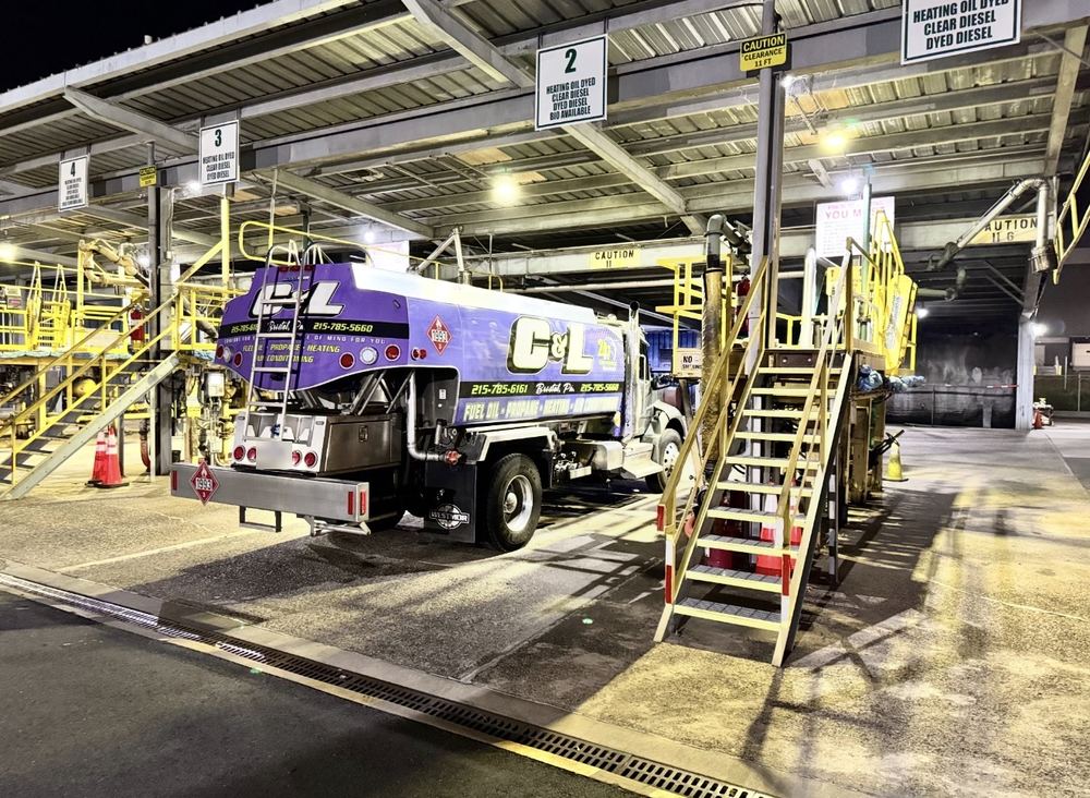 C&L Fuel heating oil delivery truck at a fuel loading rack at night