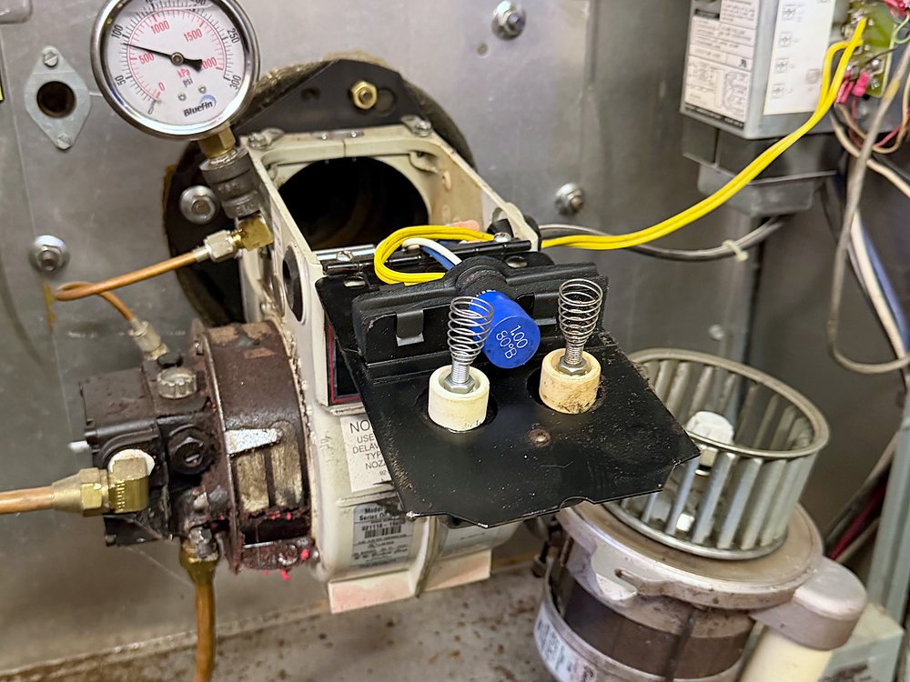 Oil burner pulled out of a boiler for service, electrodes visible