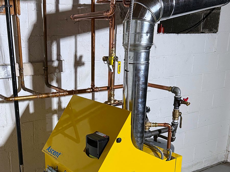 Yellow Energy Kinetics Ascent gas boiler installed in a basement, with copper piping and zone valves