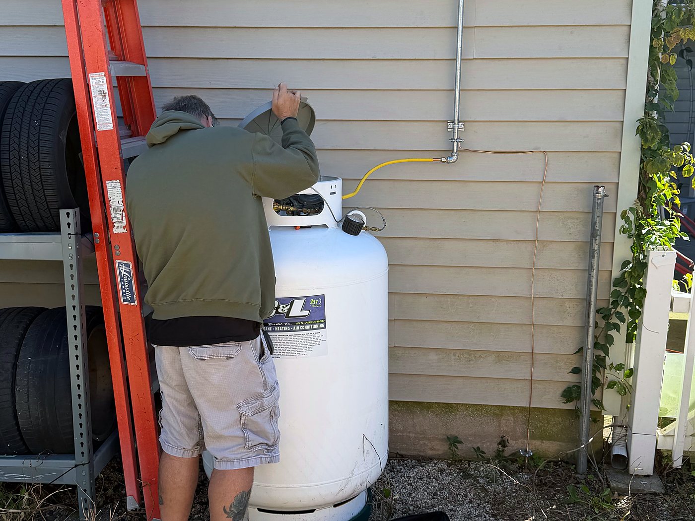 C&L technician lifting the dome on a white propane tank