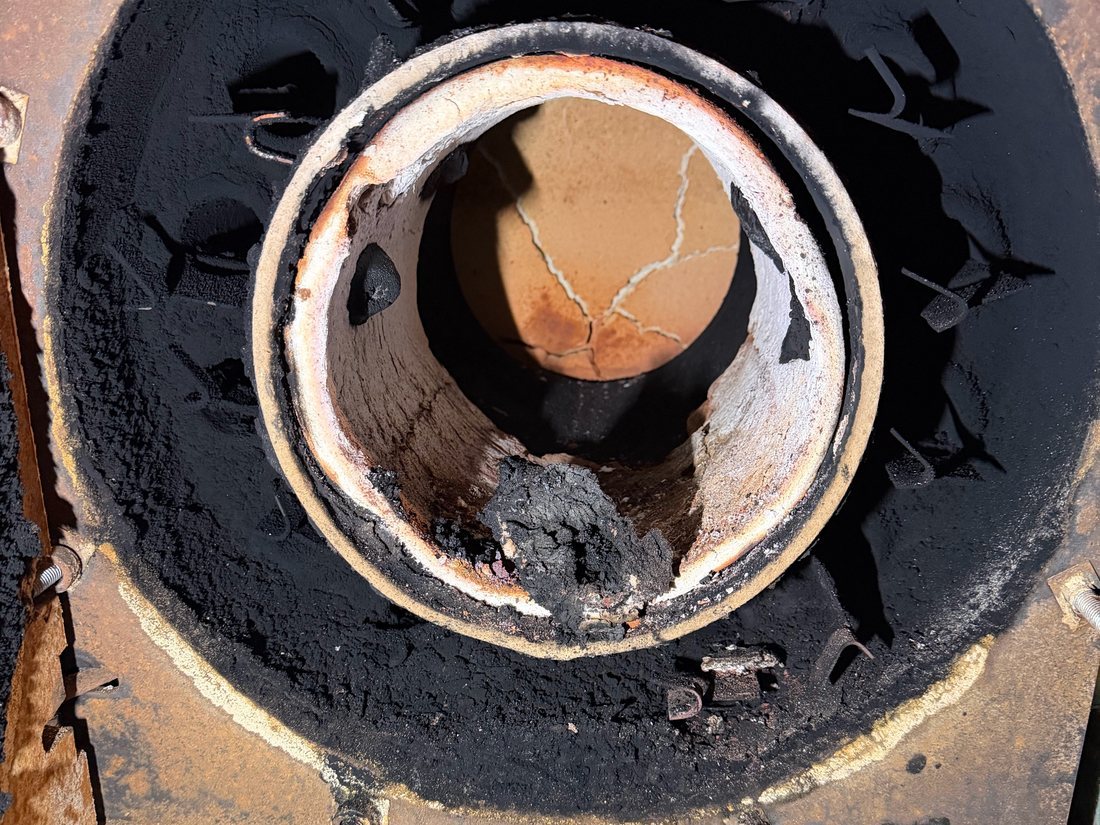 Before: oil boiler combustion chamber with heavy soot and a cracked liner